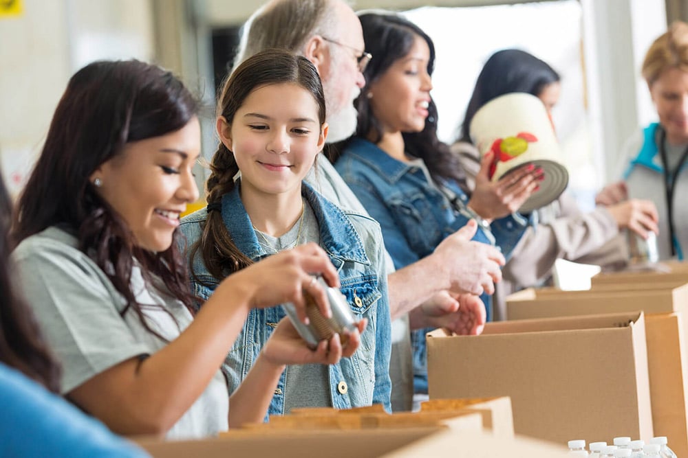 Volunteers pack canned food in community food drive